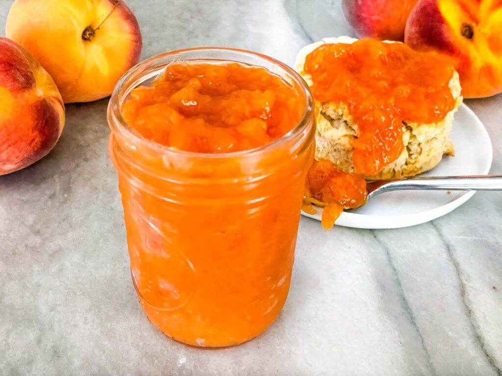 A jar of Peach Jam on a counter