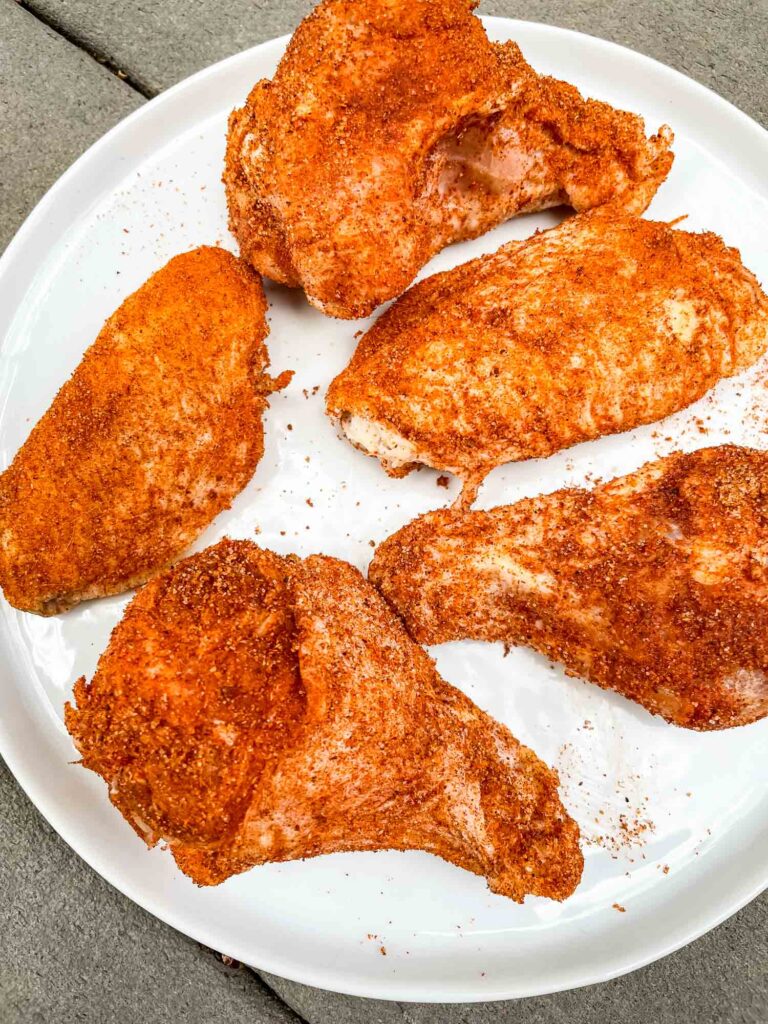 The raw chicken with dry rub on it