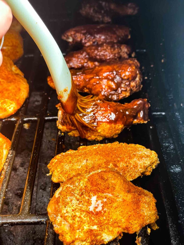 A brush basting the wings in the smoker