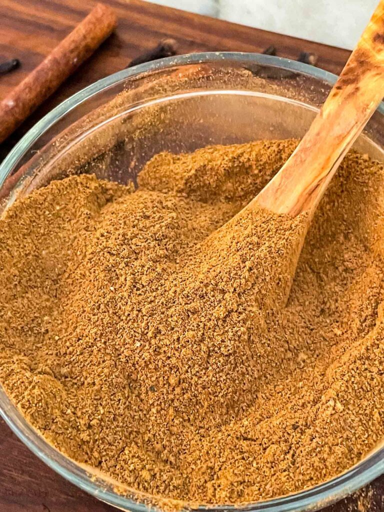 Chai Spice mixed in a small bowl with a wood spoon