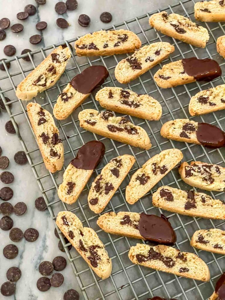 Chocolate Chip Biscotti laying on a cooling rack with chocolate chips around them