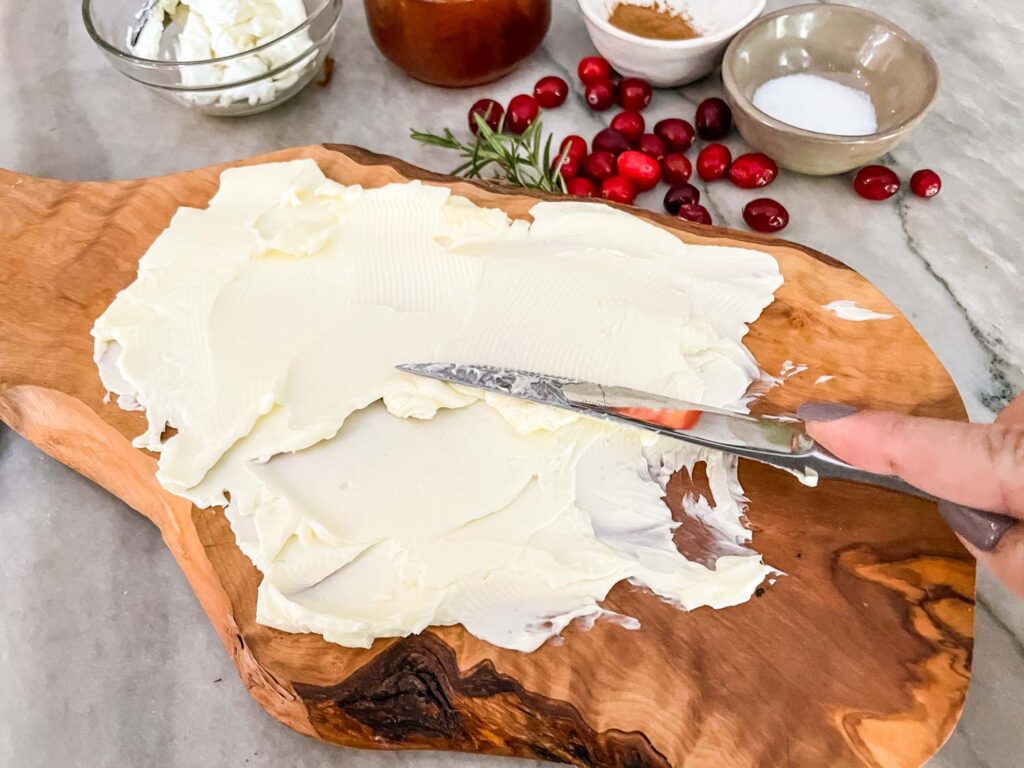 A knife spreading butter onto a board