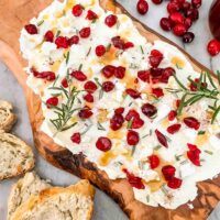 Cranberry Butter Board on a counter with bread around it