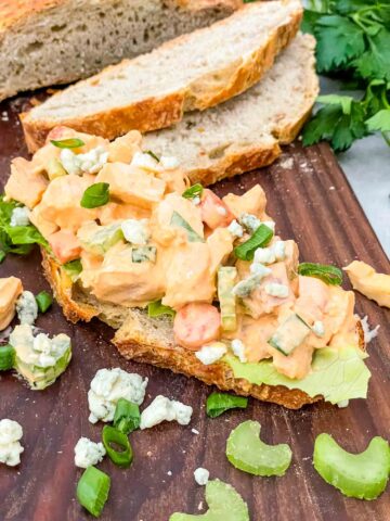 Buffalo Chicken Salad on a piece of bread on a cutting board