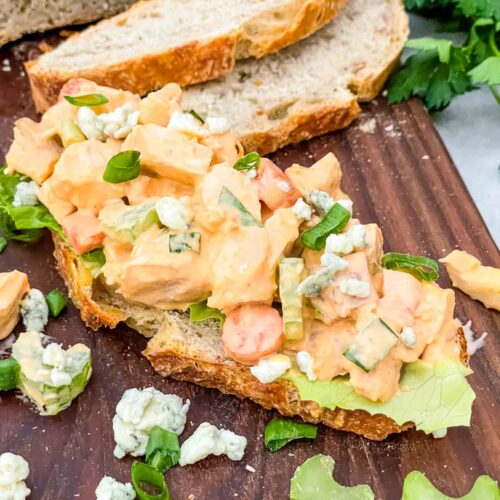 Buffalo Chicken Salad on a piece of bread on a cutting board