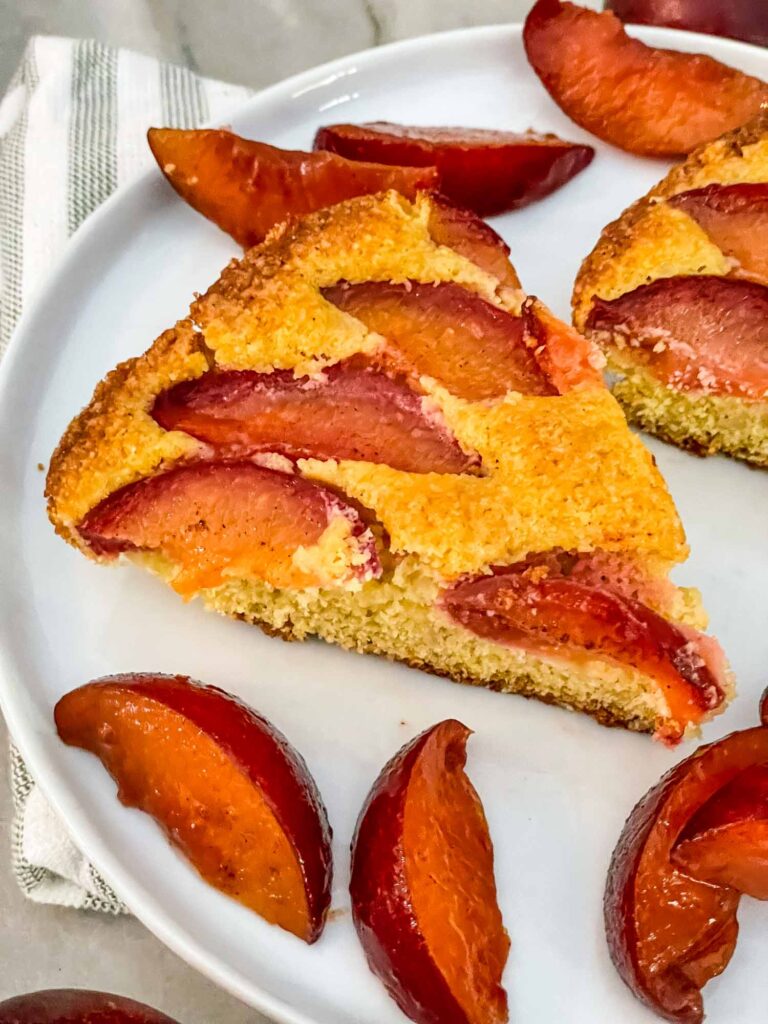 A slice of Plum Cake on a white plate