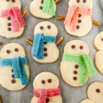 Shortbread Snowman Cookies with scarfs on a counter