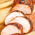 BBQ Pork Tenderloin being sliced on a cutting board