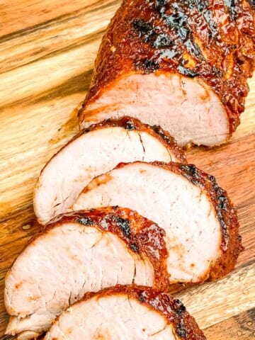 BBQ Pork Tenderloin being sliced on a cutting board