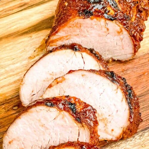 BBQ Pork Tenderloin being sliced on a cutting board