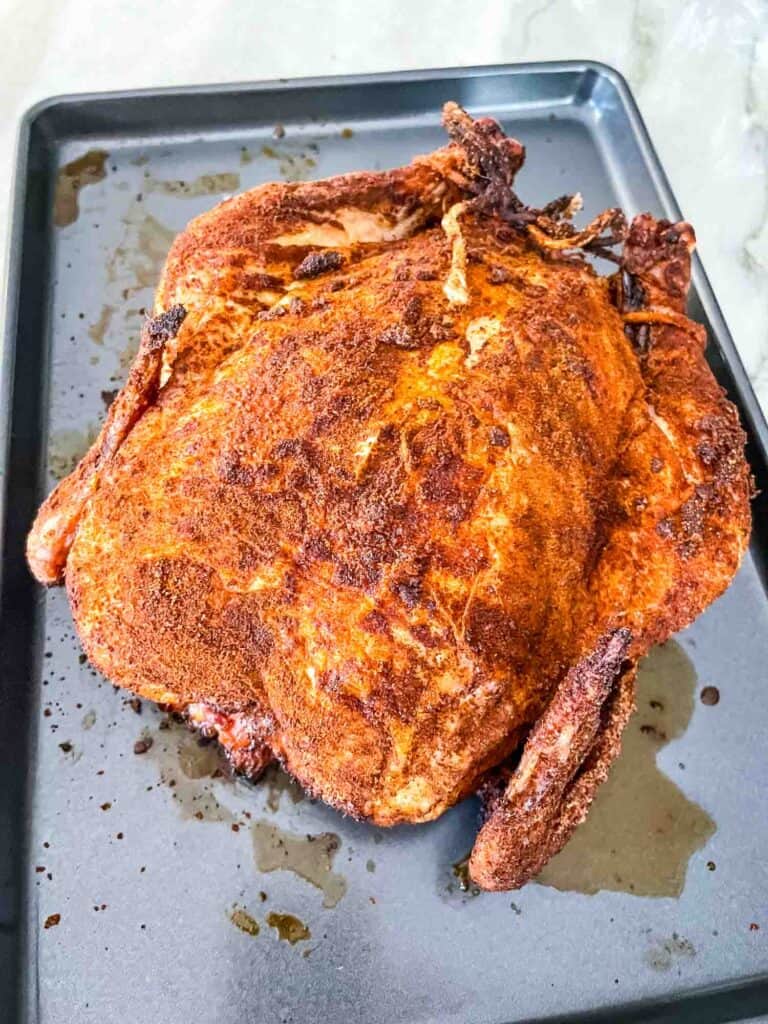 The Smoked Whole Chicken resting on a baking sheet after cooking