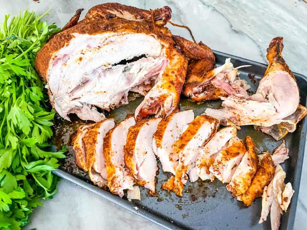 Smoked Whole Chicken sliced up on a baking sheet