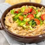 Bacon Cheeseburger Dip in a brown dish sitting on a towel