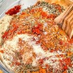 Pin of Homemade Cajun Seasoning being mixed in a bowl with title
