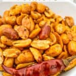 Pin of Cajun Spiced Peanuts in a white bowl with title