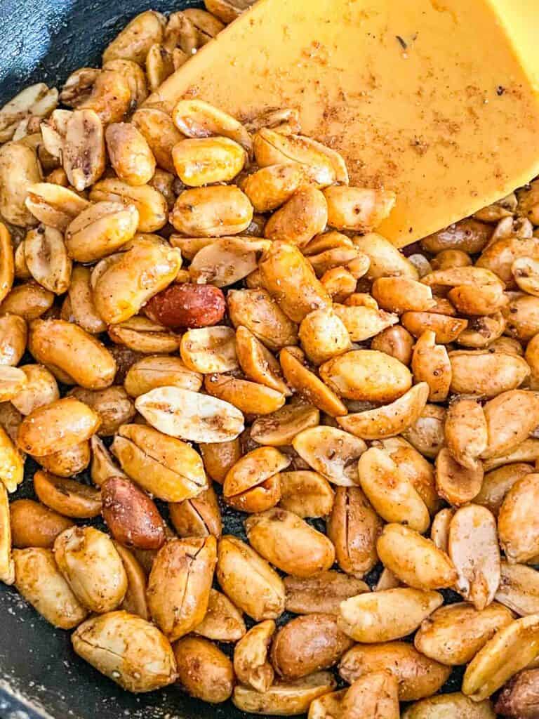 The Cajun Spiced Peanuts in a small skillet with a spatula