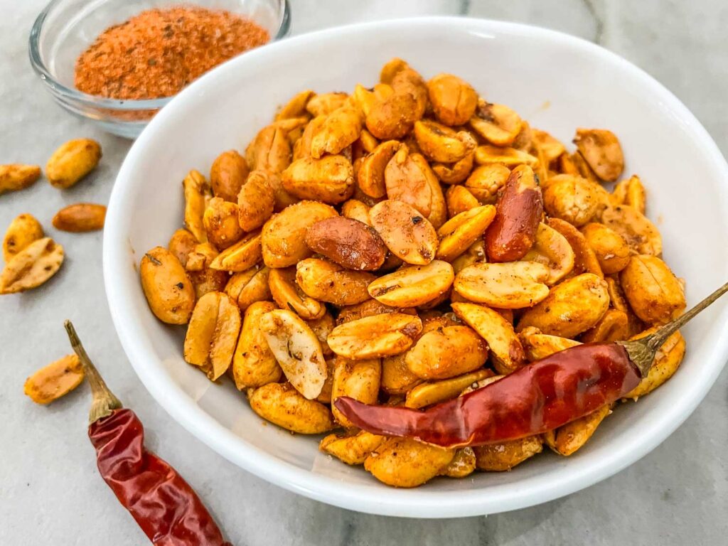 Cajun Spiced Peanuts in a small white bowl on a counter