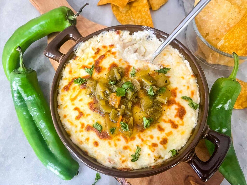 Top view of Hatch Green Chile Cheese Dip in a brown dish surrounded by peppers