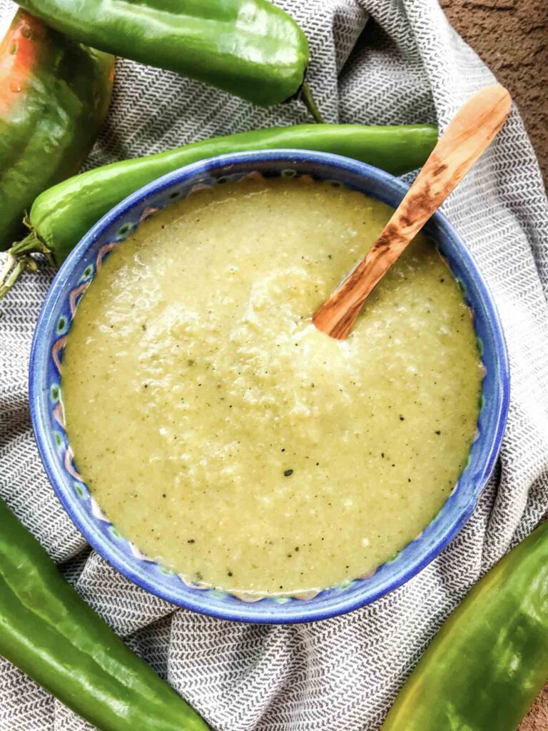 Top view of Hatch Chile Green Sauce for Enchiladas in a bowl with a small wood spoon