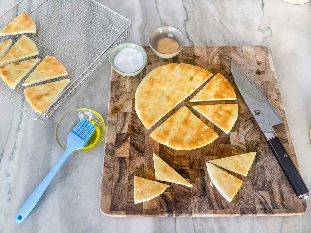 The pita being cut into pieces on a cutting board