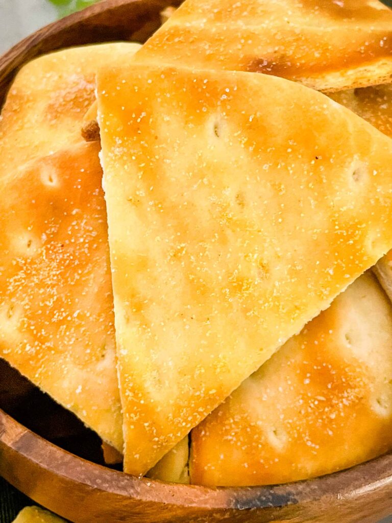 A close view of the triangular pita chips in a bowl