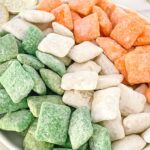 Pin of Irish colored Leprechaun Puppy Chow in stripes of green, white, and orange like the Irish flag on a plate