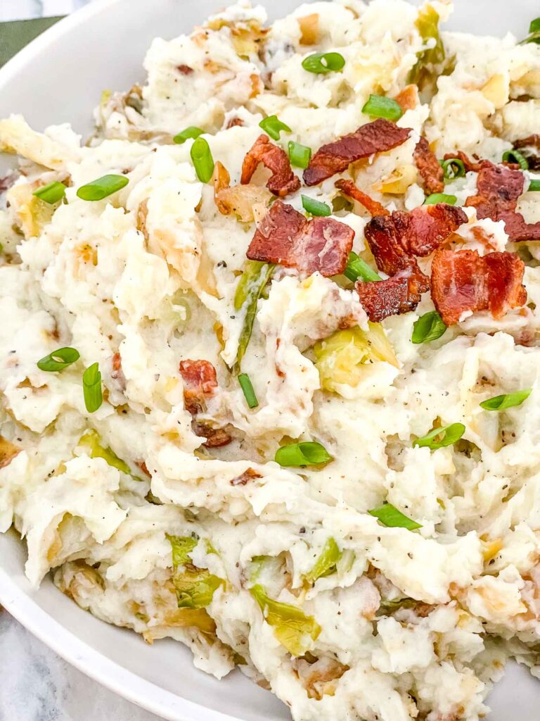 Closer view of Colcannon with Bacon in a serving dish with some bacon pieces on top