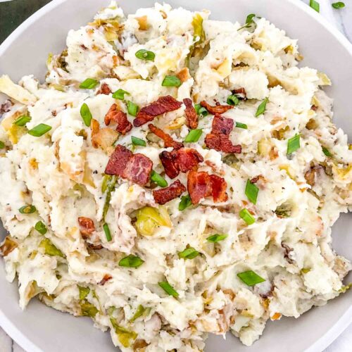 Top view of Colcannon with Bacon in a large, shallow white serving dish sitting on a counter