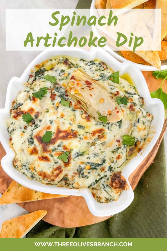 Pin of Easy Spinach Artichoke Dip in a dish shaped like an artichoke sitting on a wood board with title at top