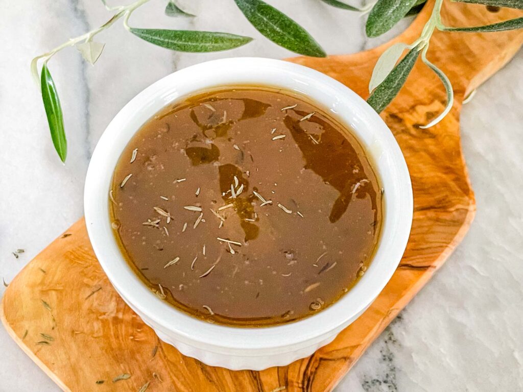 Honey Mustard Glaze in a small white dish sitting on a wood board on a counter