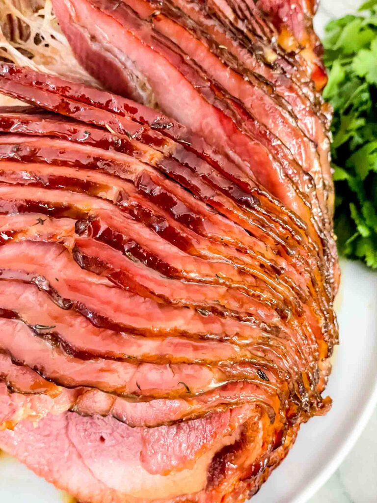 The Honey Mustard Glazed Spiral Ham fanned out after cooking on a white plate