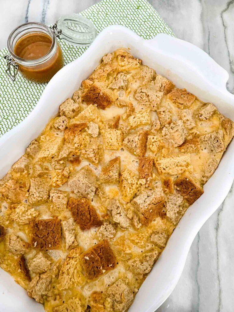 Irish Cream Bread Pudding made with Bailey's in a white dish on a counter with a green towel