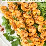 Pin of Mexican Grilled Shrimp on skewers and sitting on a bed of fresh cilantro with title at top