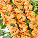 Mexican Grilled Shrimp on skewers sitting on cilantro