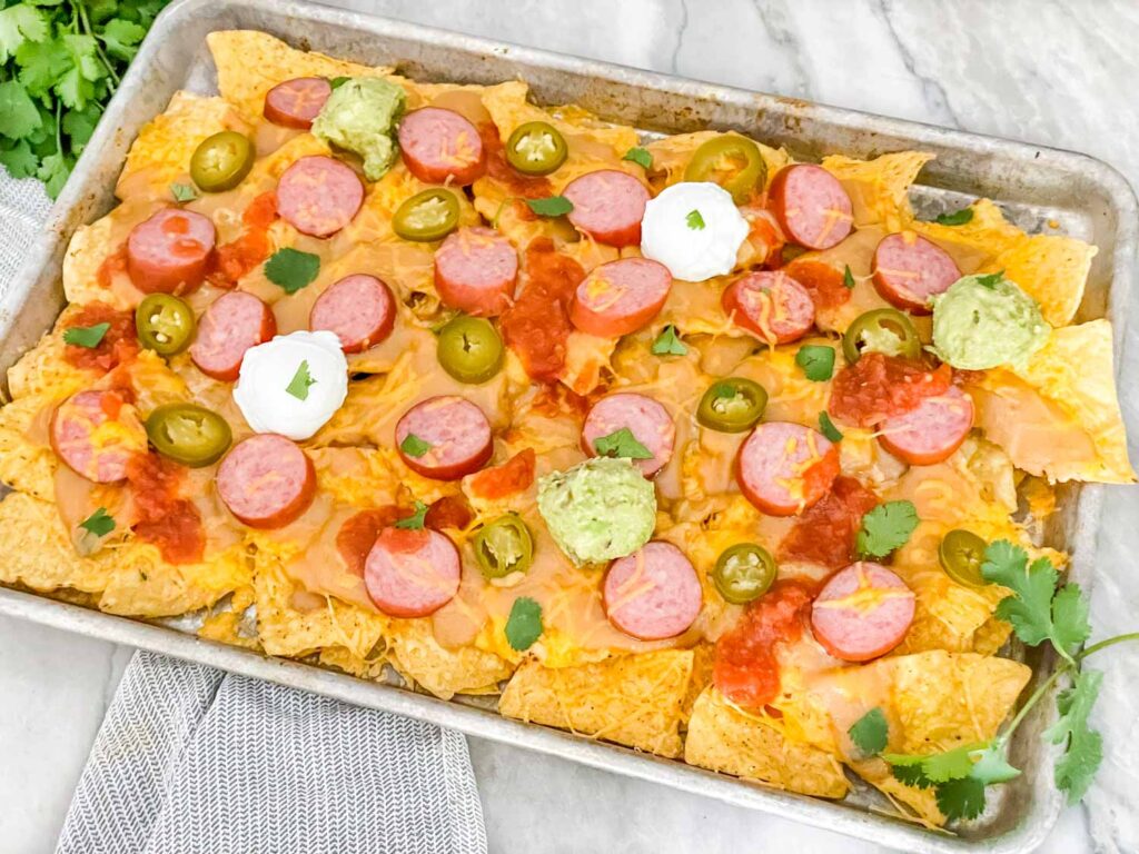 A baking sheet full of Sausage Beer Cheese Nachos on a counter