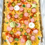 A full baking sheet full of Sausage Beer Cheese Nachos