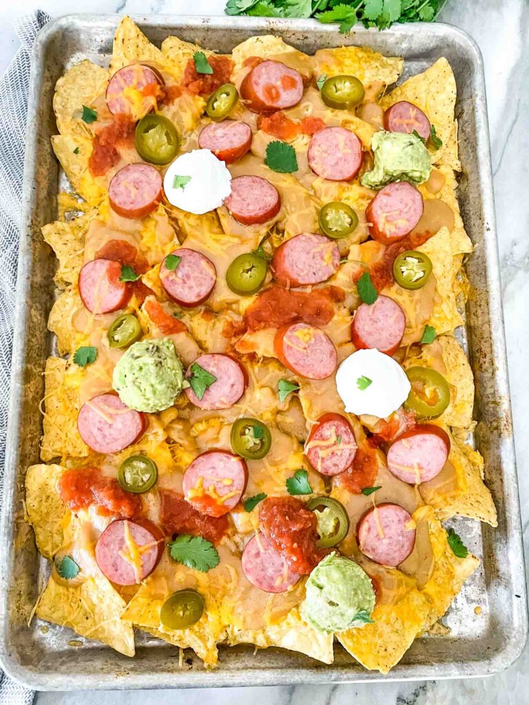 A full baking sheet full of Sausage Beer Cheese Nachos