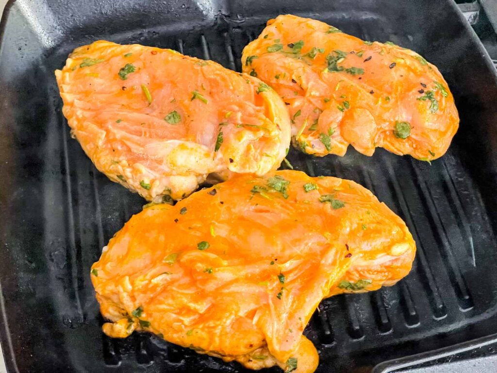 The chicken being grilled on a grill pan