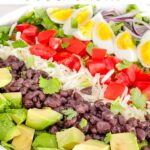 Pin of Mexican Cobb Salad up close with the toppings in rows and title at top