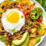 A plate of Pork Carnitas Green Chilaquiles with Eggs from the top view