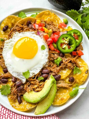 A plate of Pork Carnitas Green Chilaquiles with Eggs from the top view