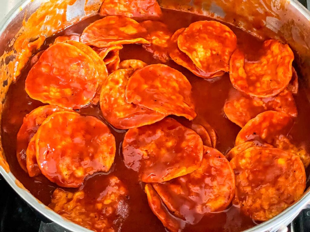The chips being tossed in sauce