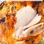 Pin of Italian Herb Butter Roasted Turkey being sliced with title at top.