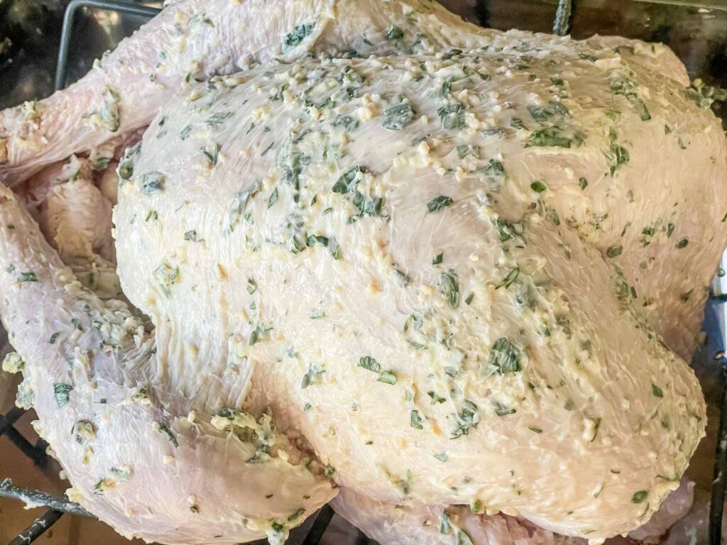 The raw turkey coated in butter and ready to be cooked