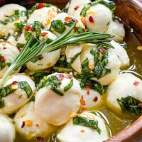 A close view of Marinated Mozzarella Balls in a wood bowl