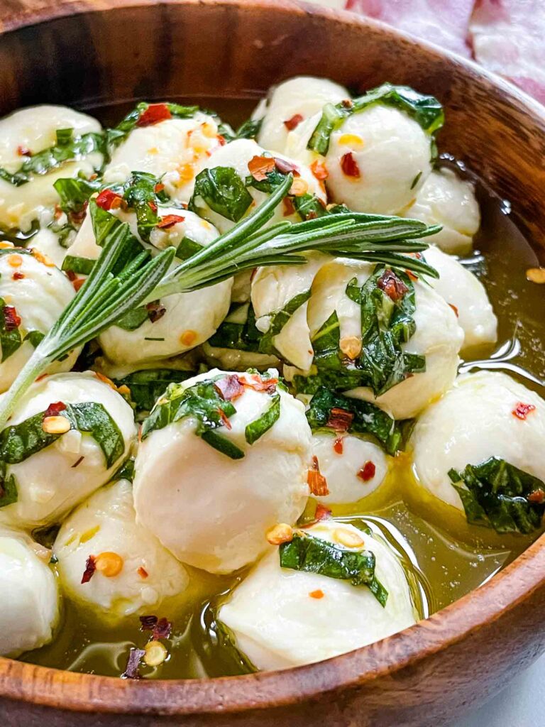 A close view of Marinated Mozzarella Balls in a wood bowl