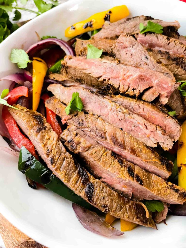 Closer view of sliced Chipotle Steak Fajitas in a white bowl