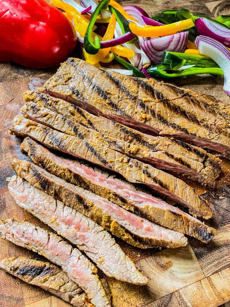 The Chipotle Steak Fajitas being cut on a wood cutting board