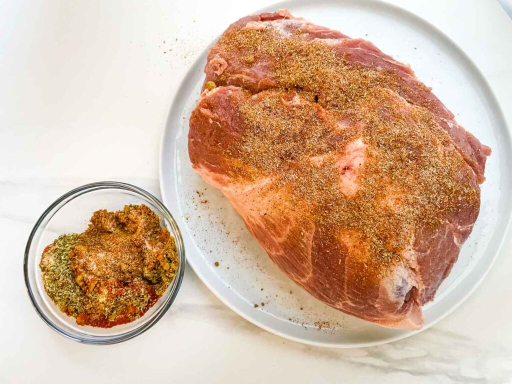 Dry rub being added to the pork.