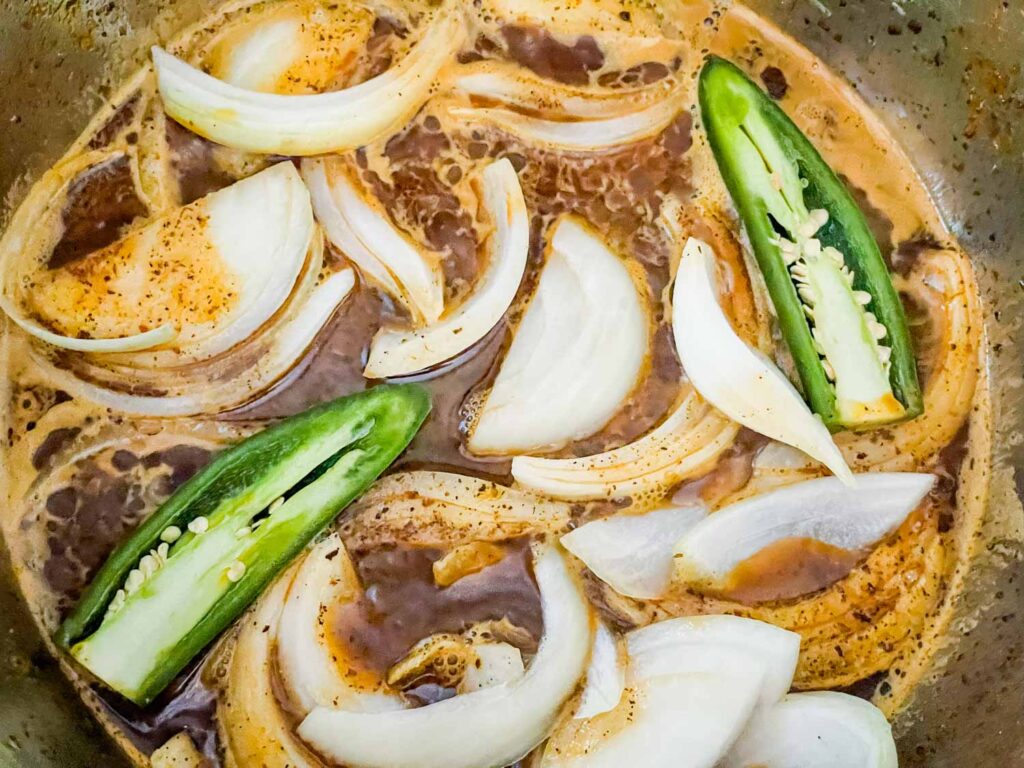 Vegetables sitting in a liquid in the pot.